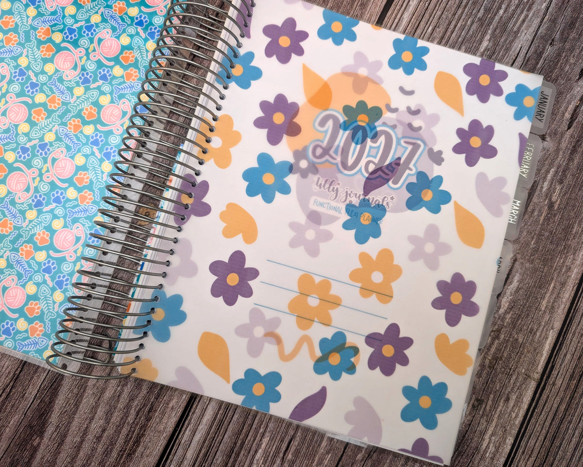 A colorful 2016-themed spiral-bound notebook with a floral pattern is placed on a wooden surface.